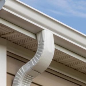 A white gutter system installed on a roof